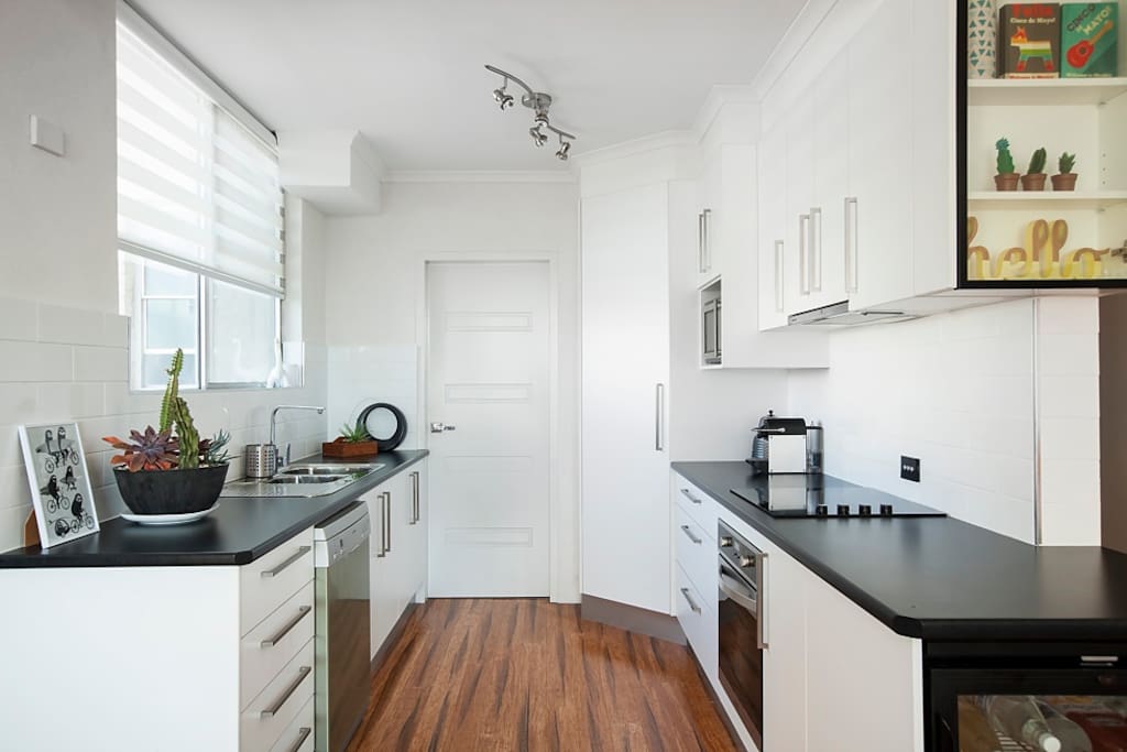 Modern kitchen with fridge, cooking facilities including oven/stove, dishwasher, microwave, plus all your required cooking and dining essentials.