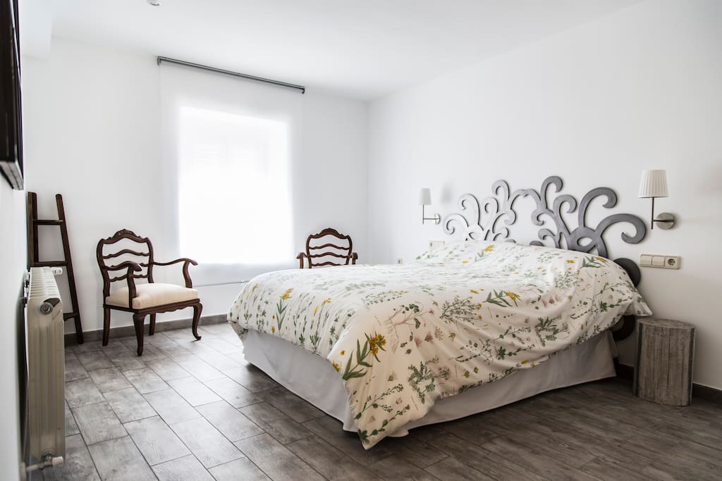 Dormitorio principal en planta baja con cama de 150x190, con ventana a la plaza del pueblo con armario empotrado