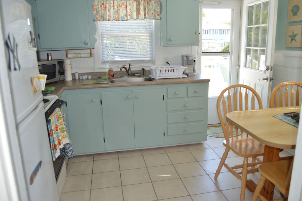 Bright kitchen with stove, oven and full size refrigerator. Microwave, toaster and coffee maker.