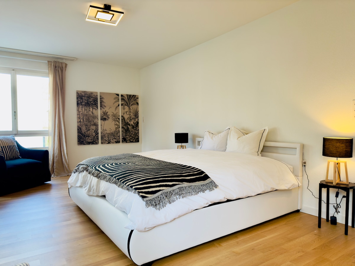 Habitación con cama principal con aire acondicionado y baño a ras de suelo.