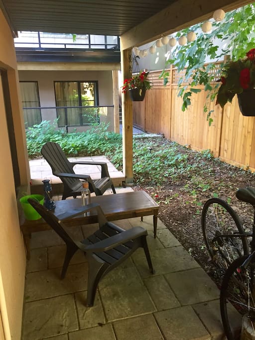 Private patio with Muskoka chairs, sharing table, lantern and solar lights.
