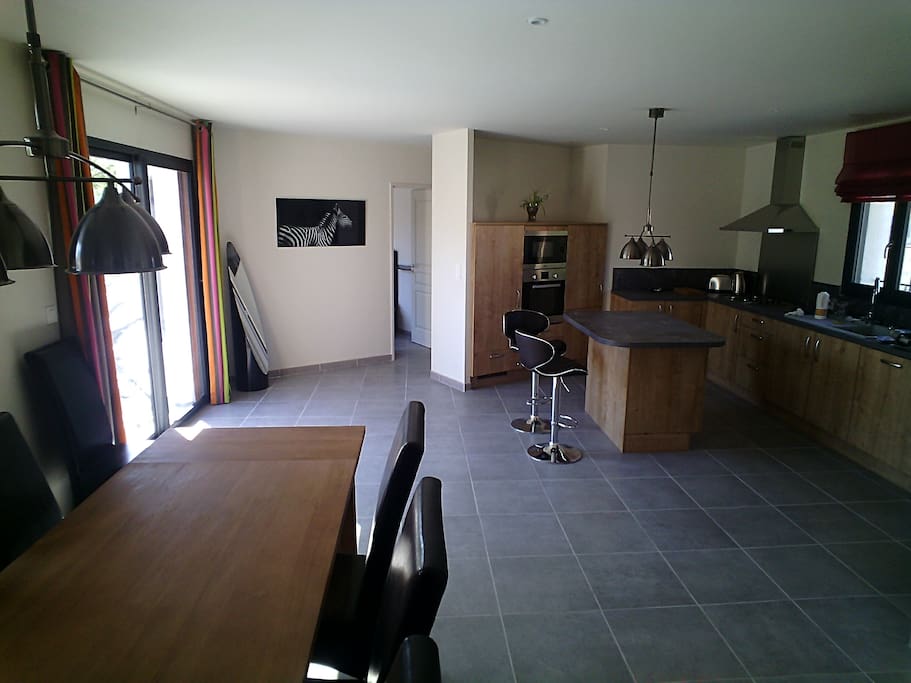 La salle et la cuisine. En face, 2 chambres avec douche.