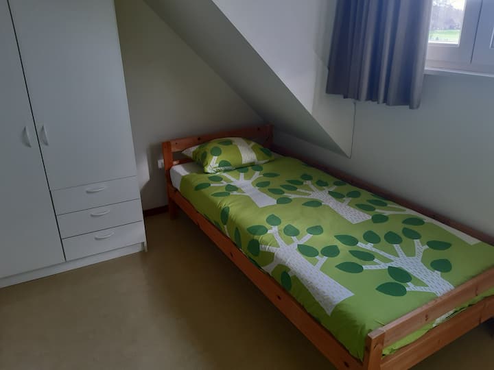 Dormitorio con 2 camas de una plaza con armario.