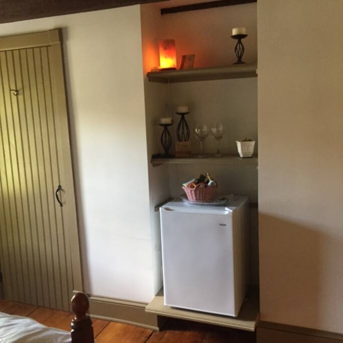 In room refrigerator with complimentary bottled water and snack basket