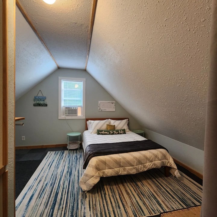 חדר שינה למעלה עם מיטת קווין סייז. שולחן עבודה/כיסא/מנורה נוספו לאחר שצולמה. 