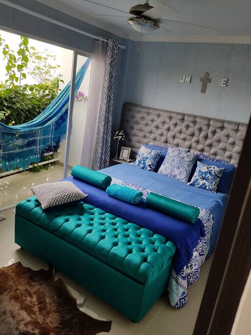 Nuestra habitación principal cuenta con cama matrimonial, balcón con hamaca, aire acondicionado, abanico, clóset, Smart TV. y baño privado.
