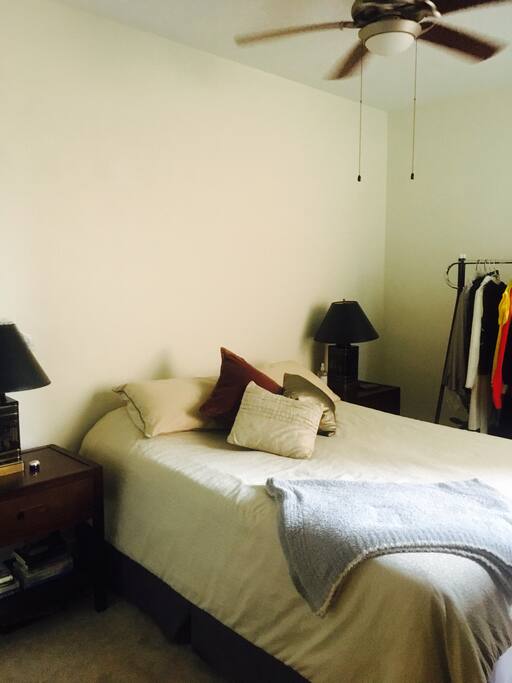 Cozy bed, rack to hang your clothes and overhead fan.