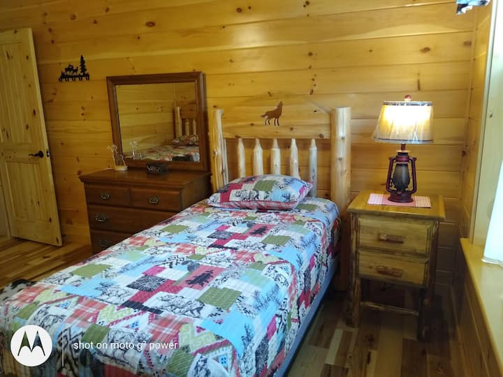 Wolf room, a wolf cut into headboard, real gas lanturns turned into lamps, extra pillows in hall closet, closet in room, extra blankets in room, ceiling fan.