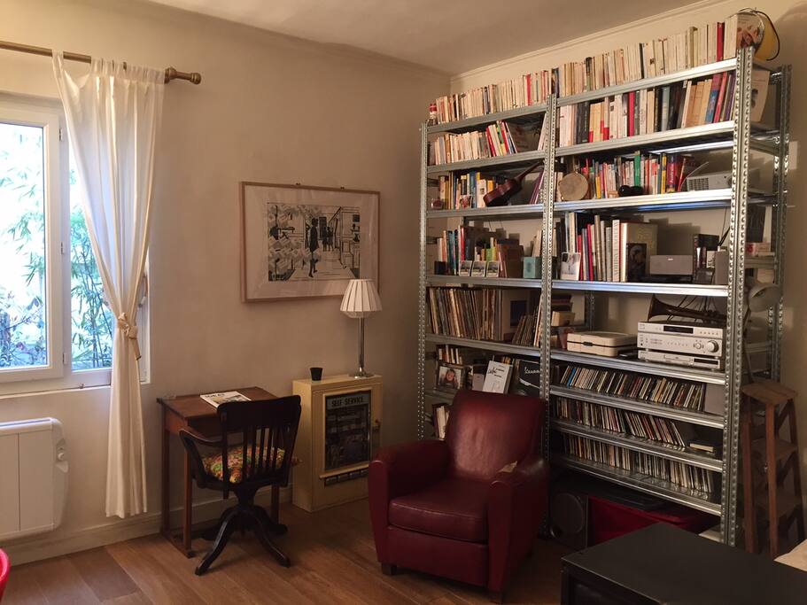 Salon avec vue sur cour arborée et fleurie
