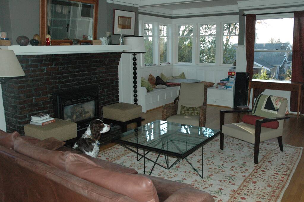 Spacious living room with fireplace, game area, and window seat