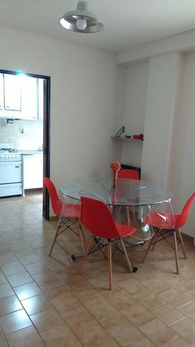 Living- comedor, mesa redonda con 4 sillas, vista hacia la cocina.