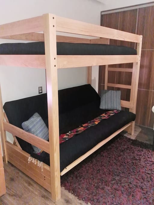El futón es una cama matrimonial, con una cama individual arriba muy cómodos, la habitación es muy iluminada y con una vista al jardín del departamento