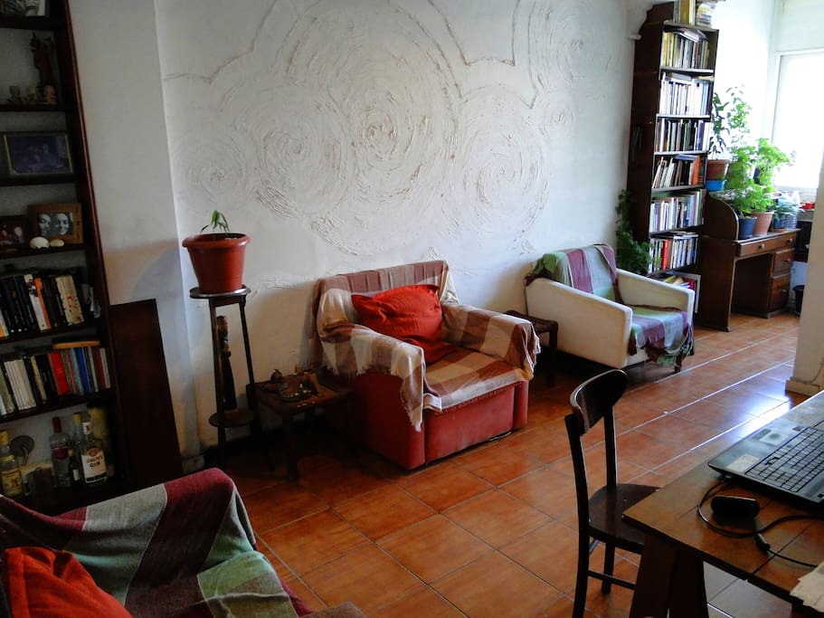 Sala de estar, sofás e livros para relaxar.