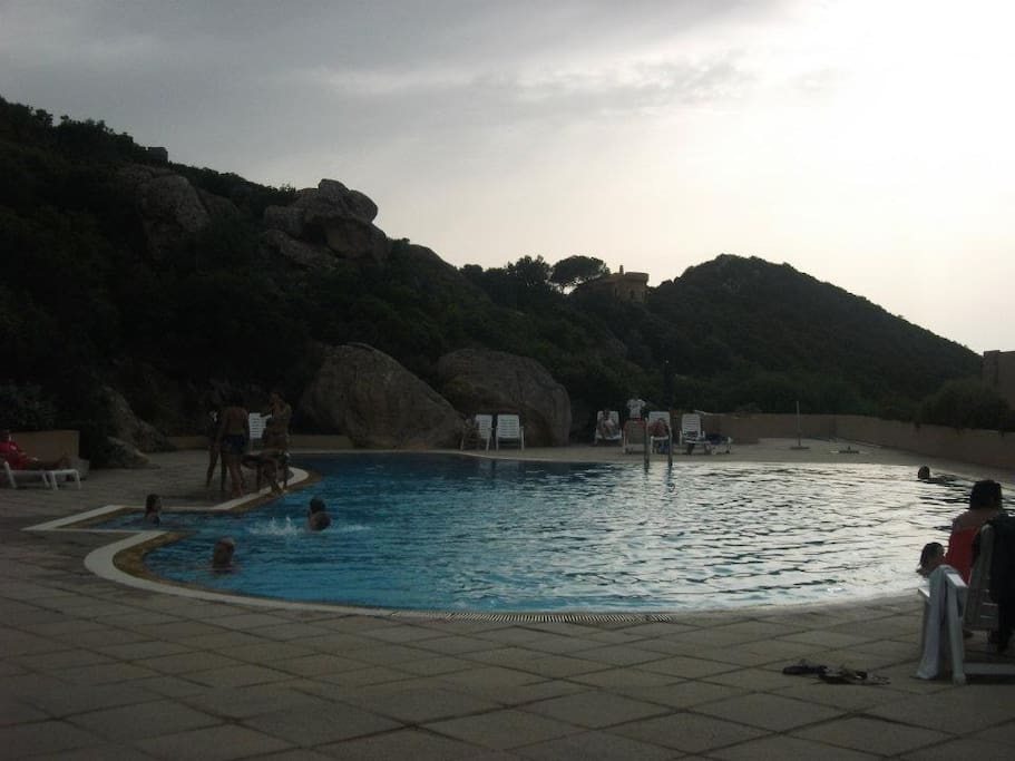 Piscina condominiale attrezzata con ombrelloni e lettini