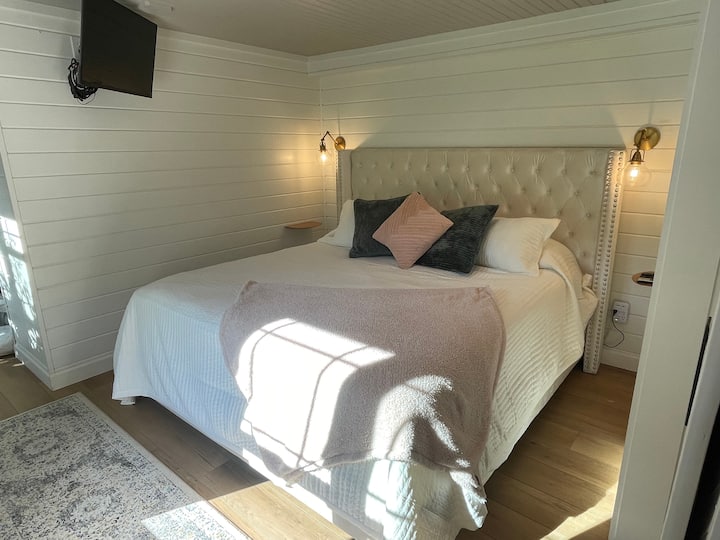 King Master-ის საძინებელი დაბლა, საცხოვრებლისა და მინი-სამზარეულოს მოედნის ქვემოთ. 
Საწოლისპირა თაროები, სმარტ-ტელევიზორი. 