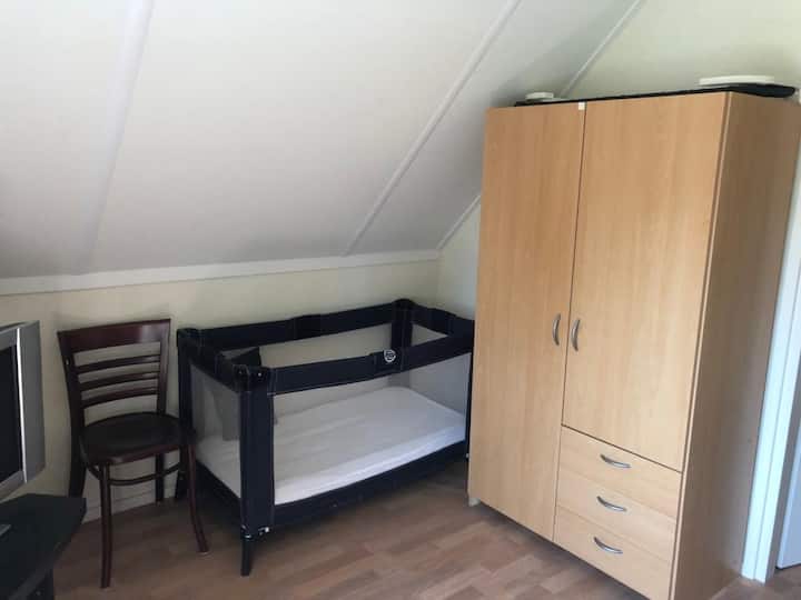 Chambre à l'étage avec lit bébé et chaise haute