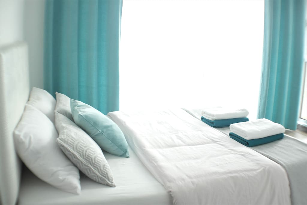 Master bedroom double bed with fresh bed linen and towels