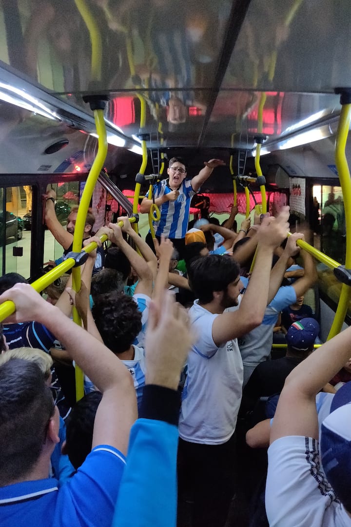 Racing fans cheering after a game on a bus