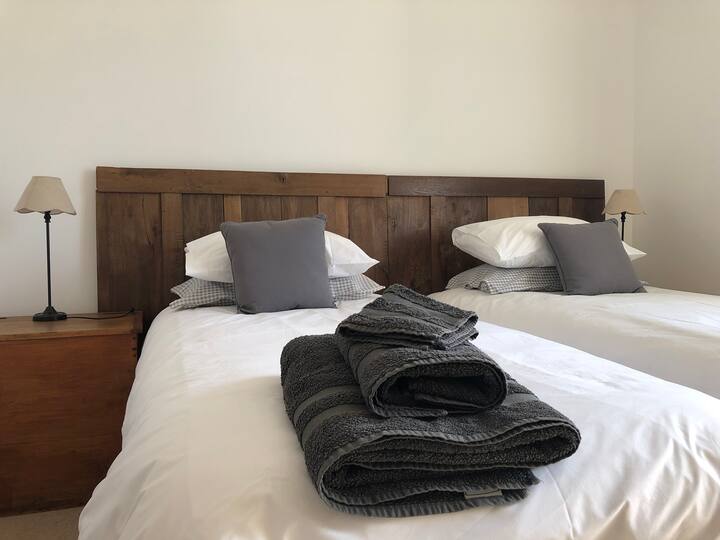 חדר שינה זוגי בקומה הראשונה עם שידת מגירות וארון בגדים עם מדפים