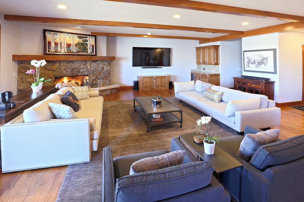 Large living room and gathering space includes wine and beer fridge, Sonos system, and large TV with Apple TV for movie nights.