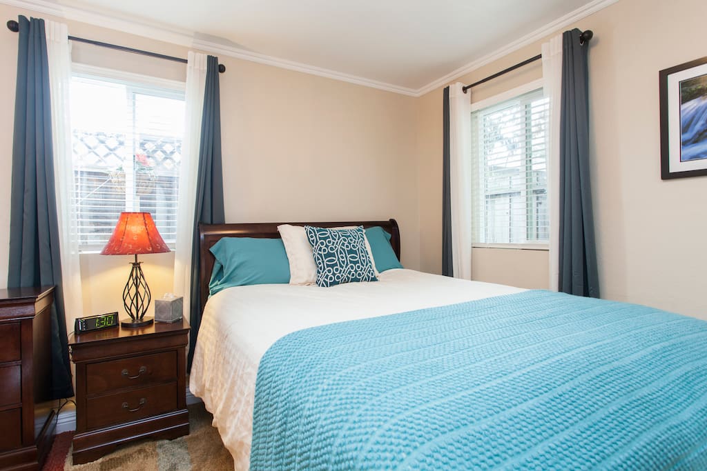The queen bed with baskets of flowers outside the window and lots of light.
