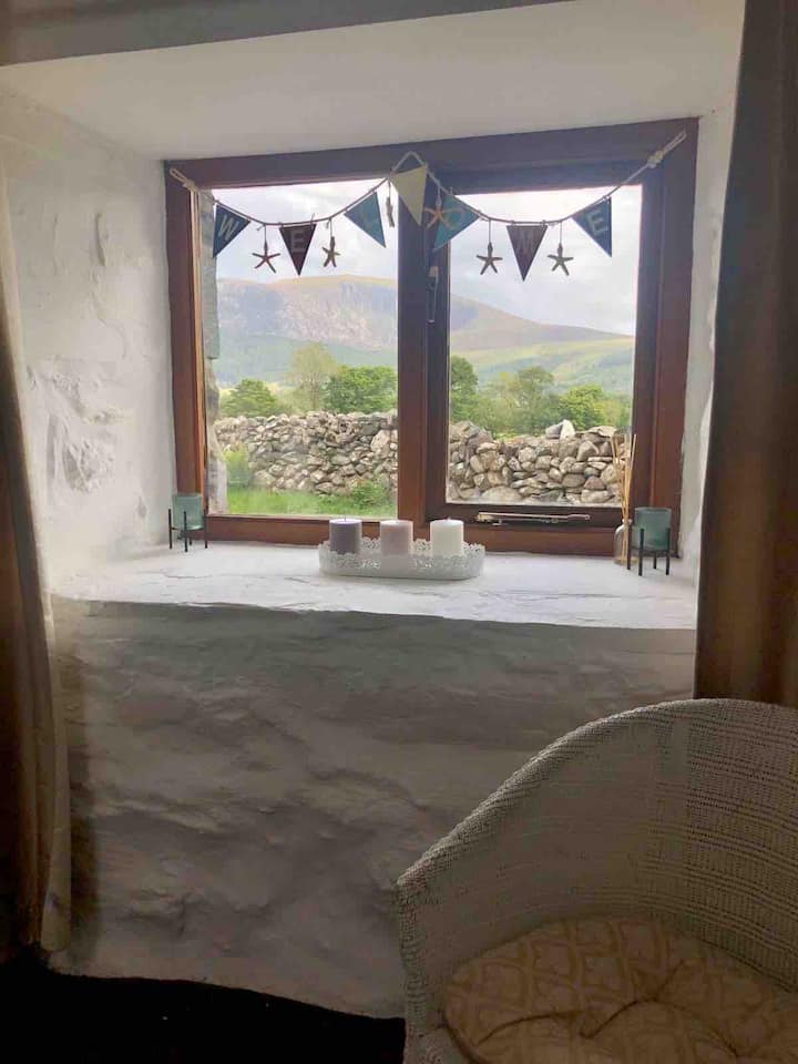 Vue par la fenêtre du salon. Mynydd Mawr est visible en arrière-plan. La montagne est affectueusement appelée la montagne des éléphants par les habitants étant donné qu'elle ressemble à un éléphant au repos !