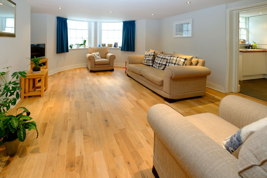 Spacious lounge with large sofa, 2 chairs and TV