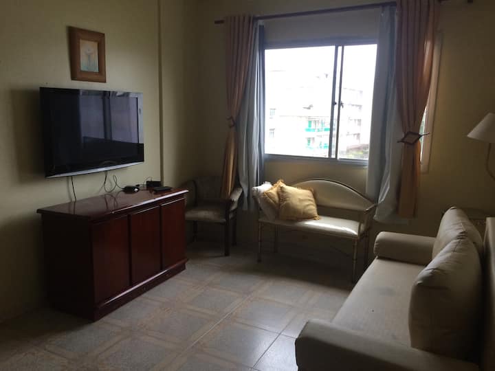 голяма всекидневна с разтегателен диван, телевизор, фотьойли, маса за хранене за 6 души.