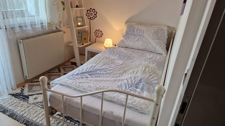 سرير مفرد في الغرفة الصغيرة مع إمكانية الوصول إلى الشرفة المنفصلة 