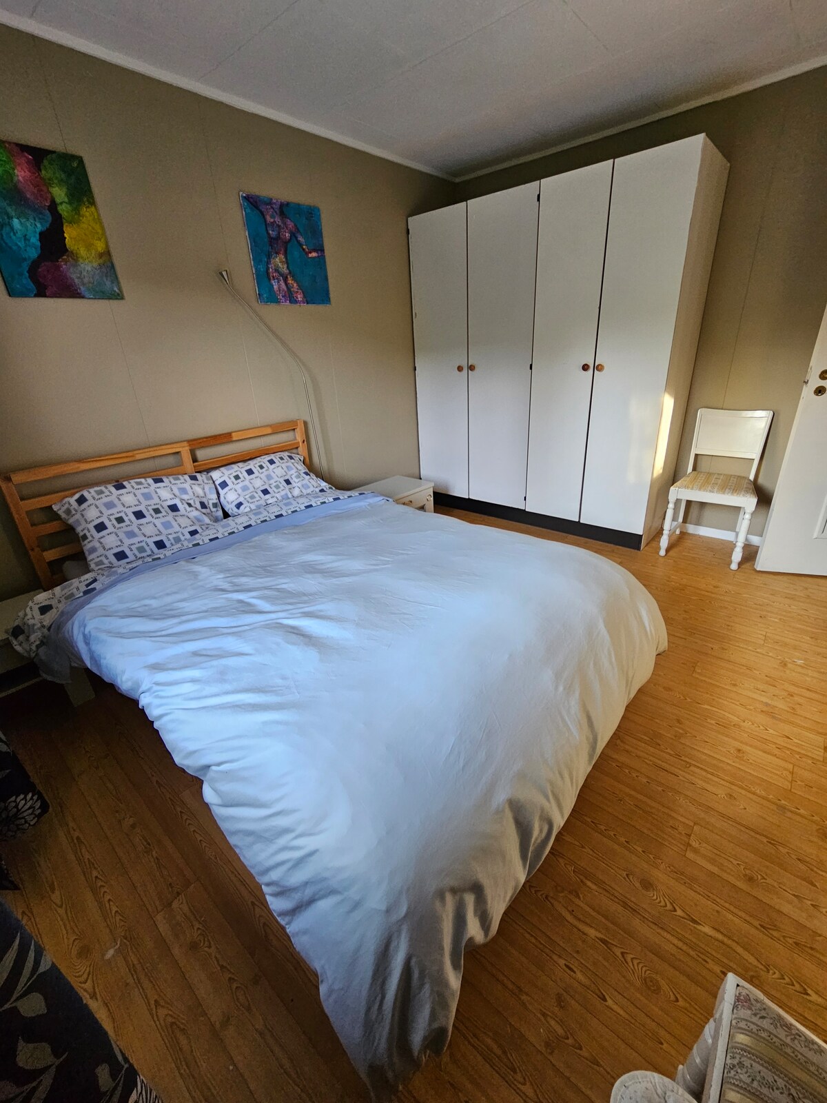 Cama de dos plazas de 140 cm  con edredón de matrimoni, 2 mesitas de noche, armario doble, 2 sillas. 