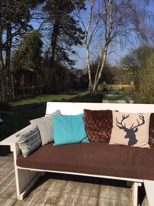 Groot, houten terras en een diepe tuin