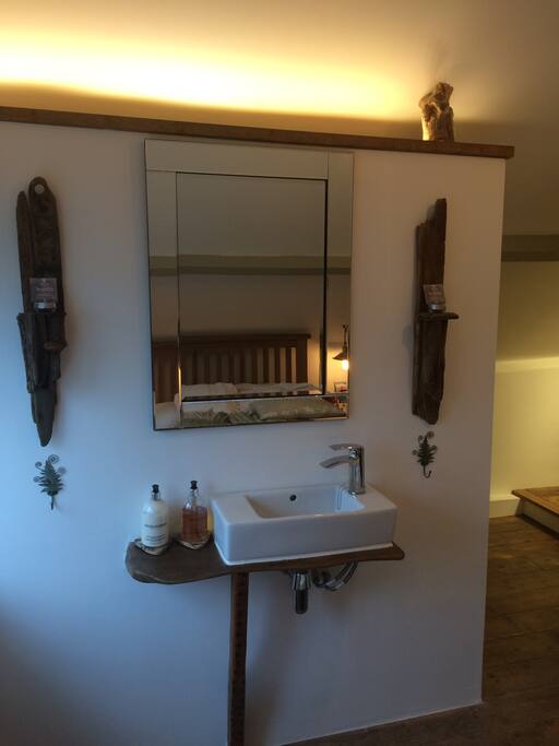 Sourced by a local Artisan.......
The 200yr old solid oak support to the contemporary basin is a feature of the loft's charm & character.
A fusion of old & new,leads you throughout the cottage theme.