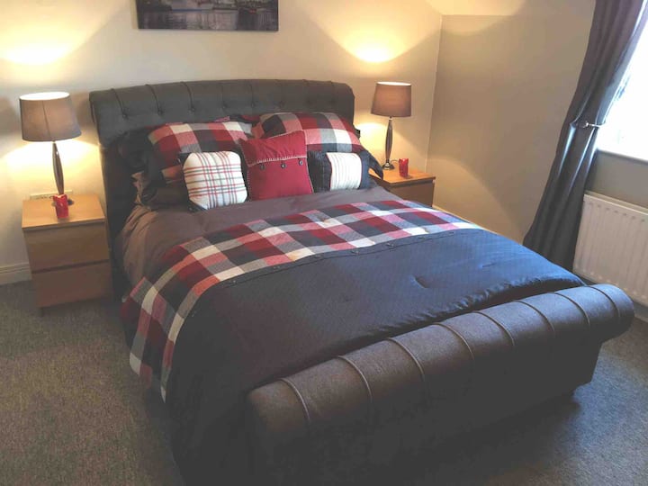 Bedroom 1 - ‘Lowry’

Stylish red and grey comforter set. Grey fabric sleigh bed and plain dye grey bedding. 
Ample wardrobe and drawer space. Wall mounted HD flat screen smart TV. 
Tiled en-suite shower room with WC and basin. 