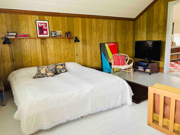 Large bedroom with sofa corner and workspace.