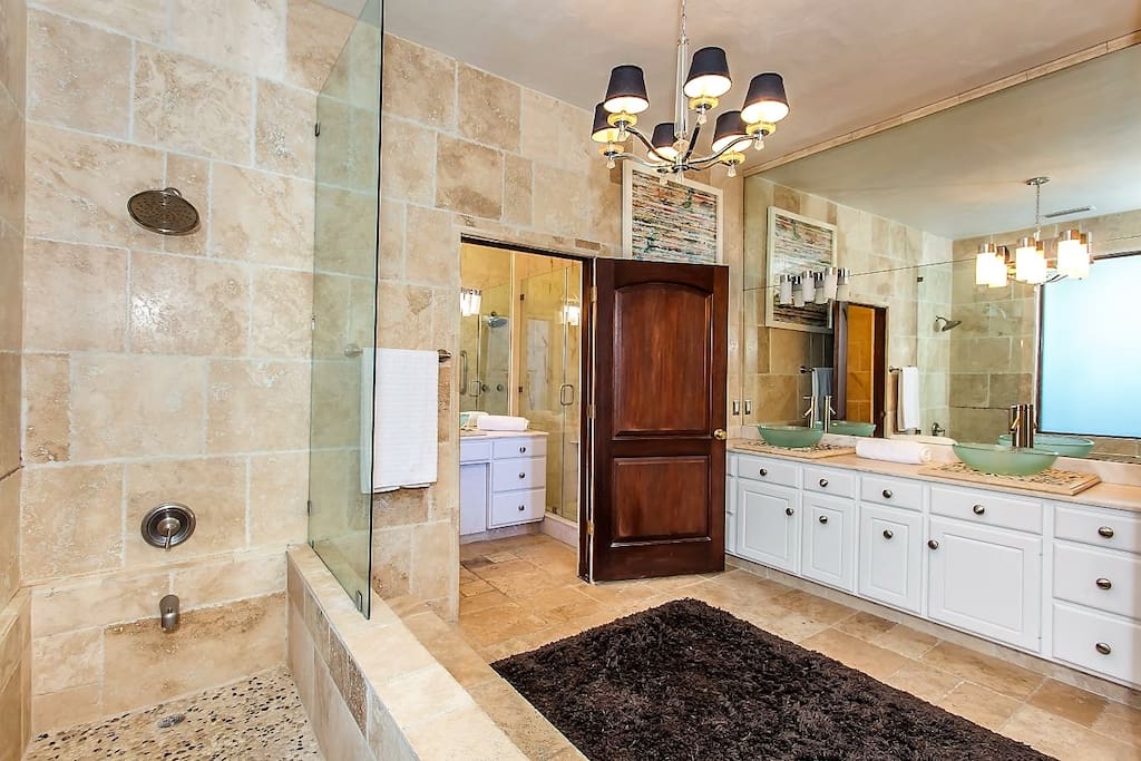 Master bathroom with deep stone-tile bathtub, dual sinks, luxury bath amenities. Jack and Jill door leads to second bathroom