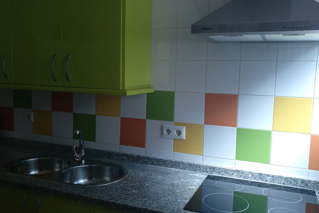 cocina con lavadora, frigorifico y horno.