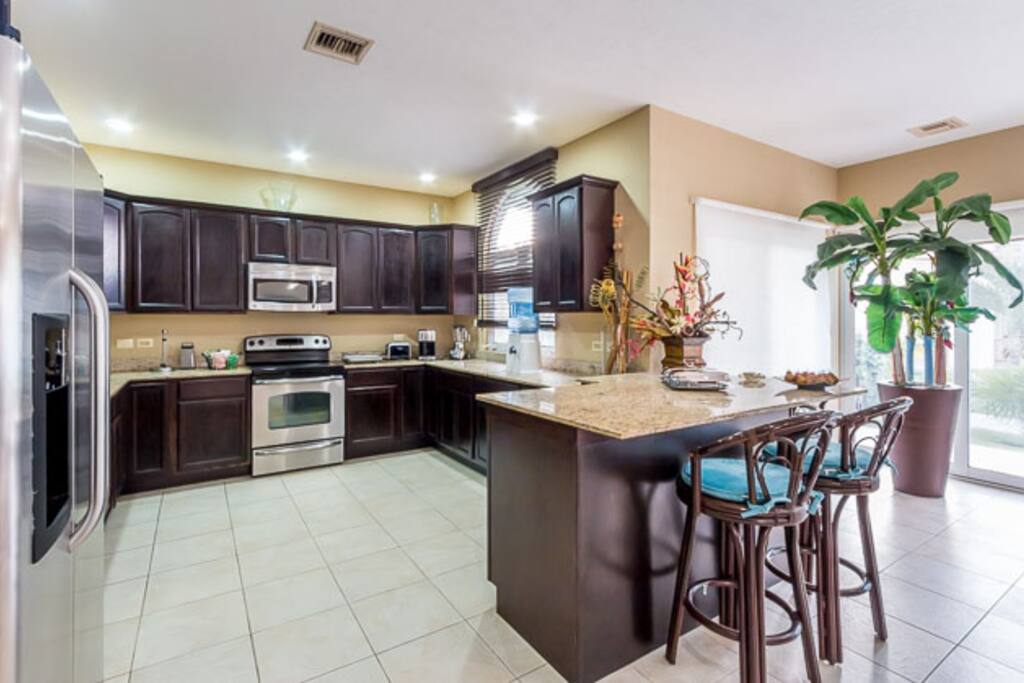 The kitchen has a small breakfast counter and comes equipped with all small and large appliances and plenty of cooking utencils