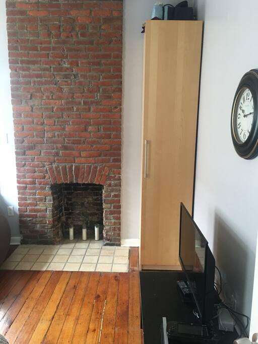 TV, Closet, and decorative fire place.