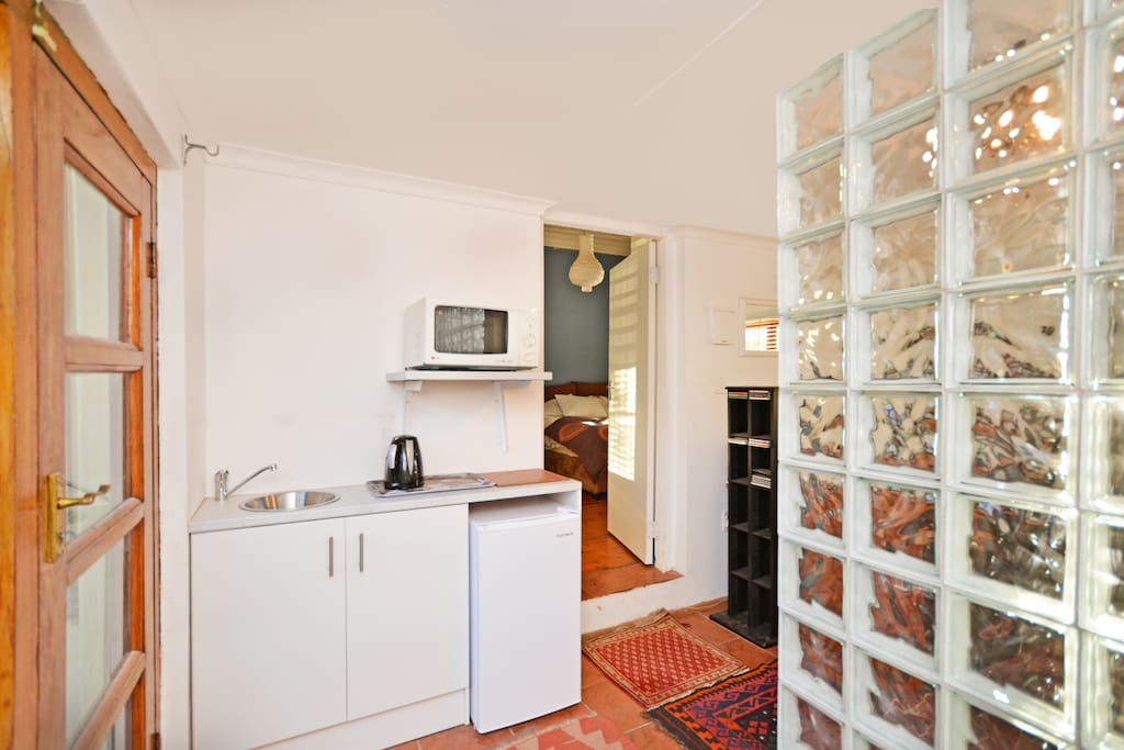 Kitchenette in 2nd room separated by a wall of glass bricks from the desk