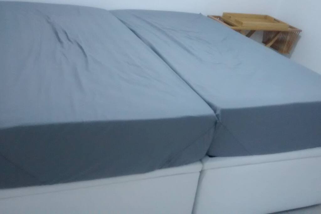 Duas camas de solteiro que ao se juntar vira uma cama de casal Queen.