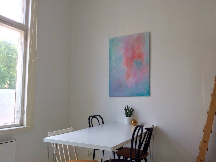 Dining table with space for four. The art made by the hosts gives color to the otherwise minimal color scheme.