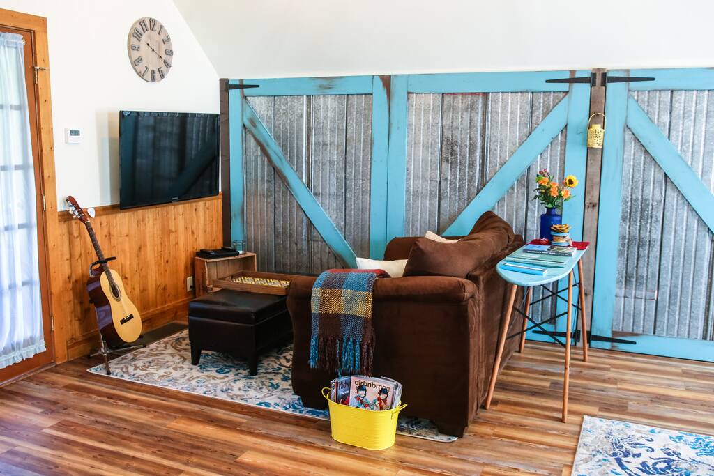 Entertainment nook with DVDs, games, guitar, books, & magazines. Streamable with Chromecast.