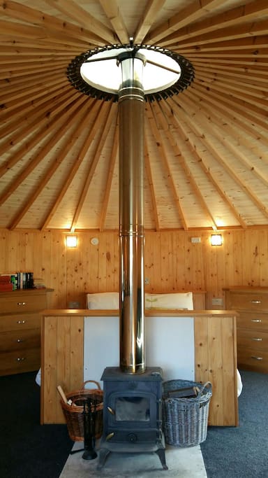 The calming space inside, all wood, showing the fire, storage facilities and the bed!