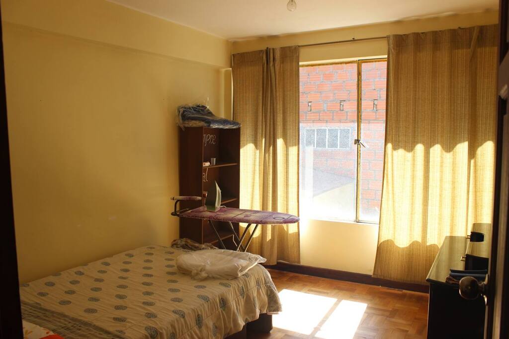 Dormitorio soleado con lo basico para guardar ropa.