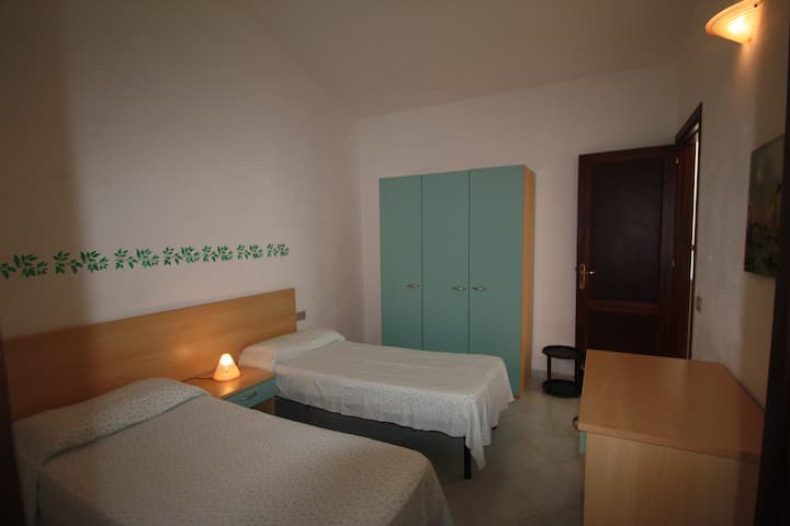 غرفة نوم بسريرين فرديين وخزانة ملابس