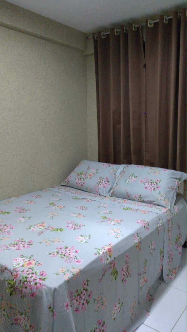 Dormitorio compuesto por cama doble y armario, con almohada y aire acondicionado.