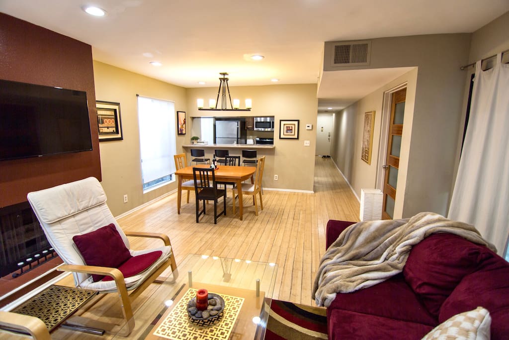 Living room with bamboo floors, sofabed, TV, decorative fireplace, table with seating for 4-6
