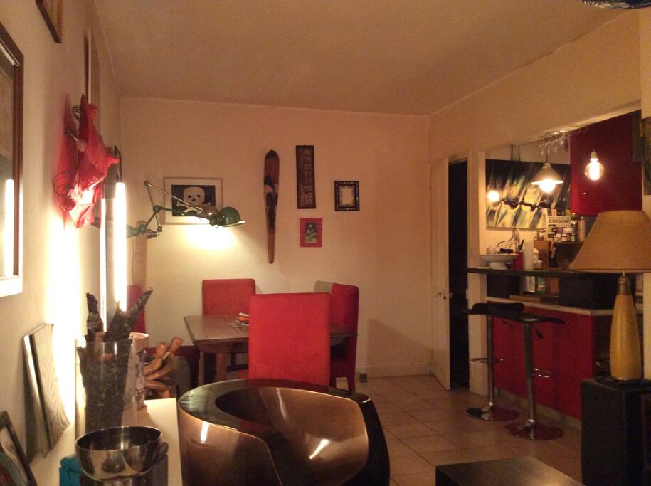 Vue sur le coin repas et la cuisine sur la droite
