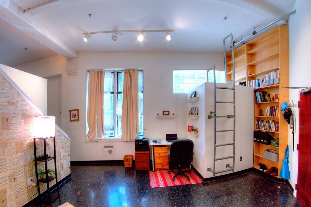 A writing desk beneath the built-in library and reading nook.