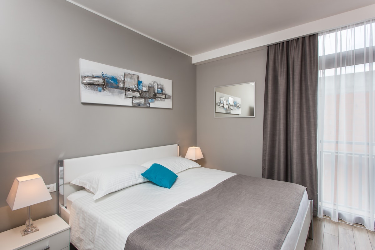 Dormitorio con cama tamaño king, aire acondicionado y TV.